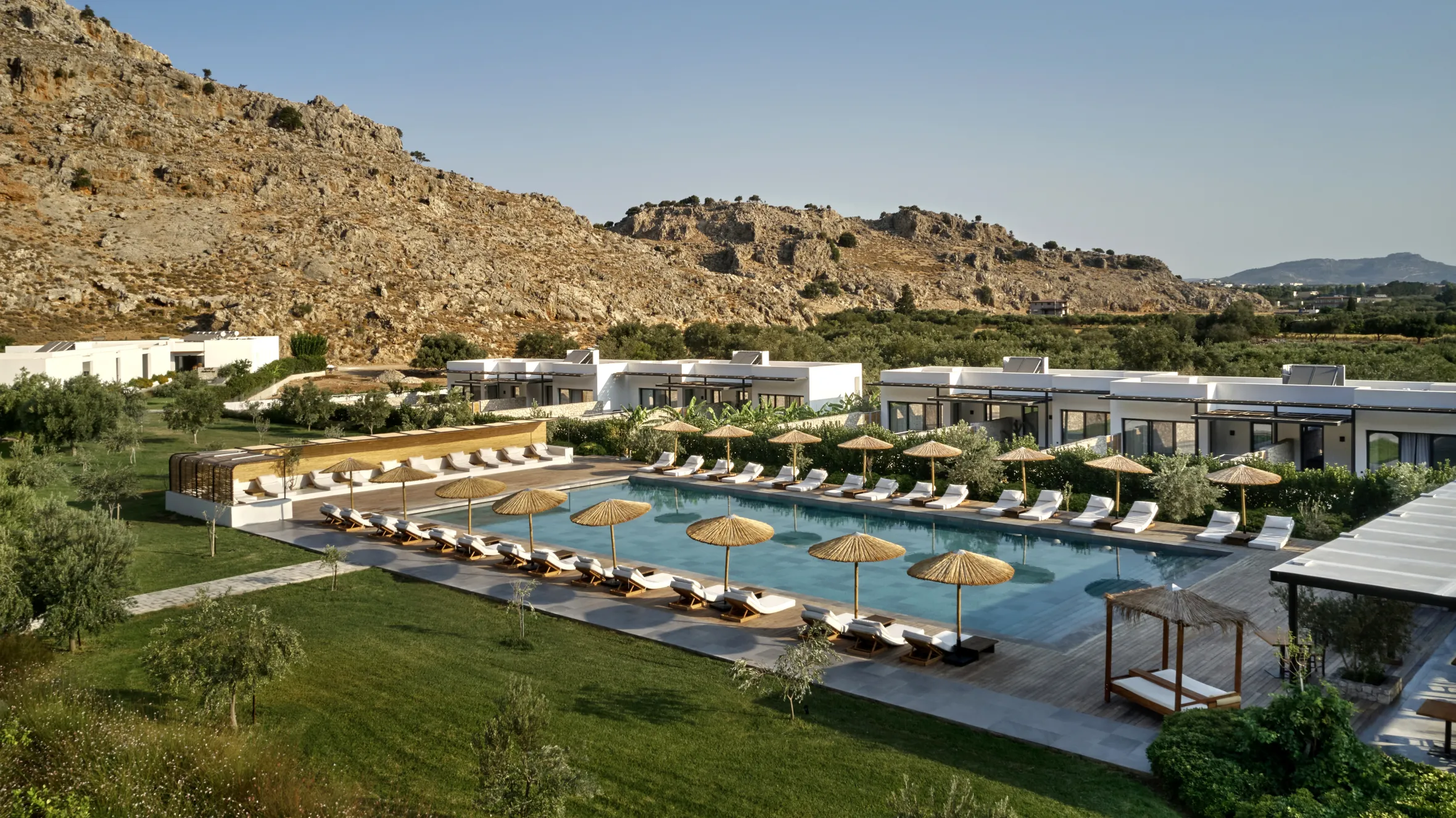 Long shaded terrace table beside a swimming pool