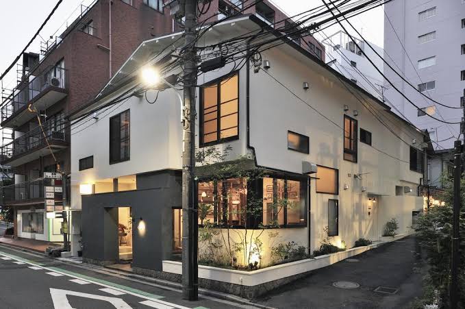 A timber house on a Tokyo street corner, with the ground floor open to the street